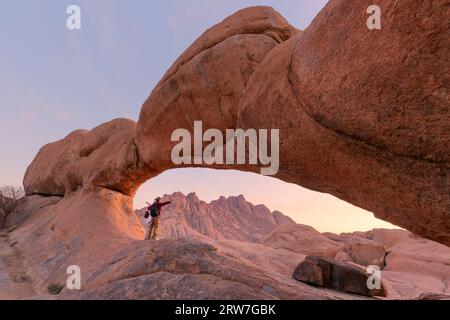 Junges Paar in Spitzkoppe mit malerischen Steinbögen und einzigartigen Felsformationen im Damaraland Namibia Stockfoto