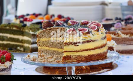 Vegan cake with cream embellished with fresh figs and poppy seeds at the market stall. Closeup with no people. Stockfoto