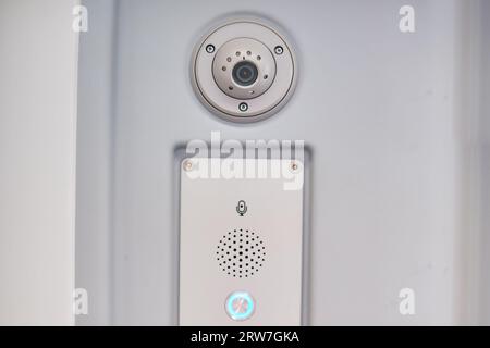 Gegensprechanlage für Passagiere mit Zugführer und CCTV-Kamera. Überwachungskamera an der Wand eines Transportes Stockfoto