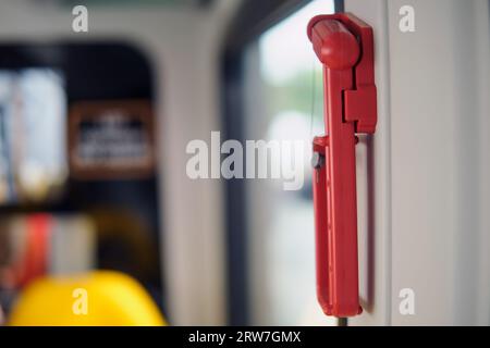 Hammerscheibe auf Zug, Straßenbahn, Bus und Auto. Rote Sicherheitsglas-Hammerbefestigung oder Aufhängung in der Nähe der Fenster zum Brechen Stockfoto