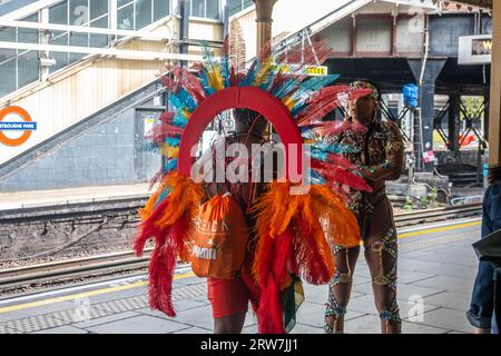 LONDON, ENGLAND - 28. August 2023: Frauen tragen Kostüme an der U-Bahn-Station Westbourne Park während des Notting Hill Carnival 2023 Stockfoto