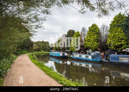 Bunte schmale Boote, die im September 2023 am Ufer des Leeds Liverpool Canal neben dem Crooke Marina bei Wigan abgebildet wurden. Stockfoto