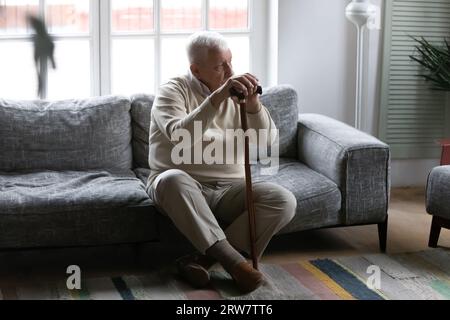 Trauriger älterer behinderter Mann fühlt sich einsam zu Hause Stockfoto