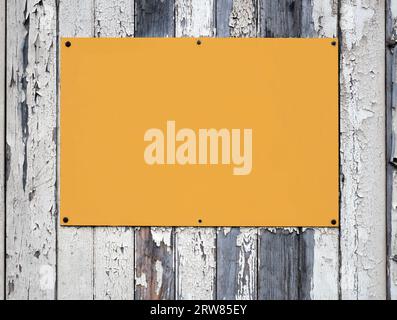 Leeres gelbes Schild auf einem Holzzaun. Stockfoto