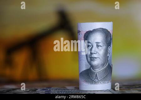 Chinesische Yuan-Banknote auf dem Hintergrund der Ölpumpenanlage. Konzept der Ölindustrie und der Preise Stockfoto