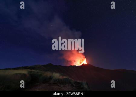 Ätna - die eindrucksvolle Landschaft in der Nacht auf dem Vulkan Sizilien während des Ausbruchs am 13. August 2023 unter dem klaren Sternenhimmel mit Rauch und Dampf Stockfoto