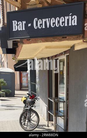 Viladecans, Spanien - 17. September 2023: Brauerei-Bar mit einem Athletenfahrrad, das vor der Tür des Gebäudes geparkt wird. Stockfoto