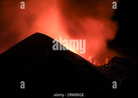 Ätna - Esplosione di Lava intensa sul vulcano etna dal cratere durante un eruzione vista di notte con Silhouette del cratere in Kontroverse Stockfoto