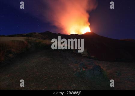 Etna e il suggestivo paesaggio di notte sul vulcano di Sicilia durante l'eruzione del 13 agosto 2023 sotto il cielo stellato nitido con fumo e vapore. Stockfoto