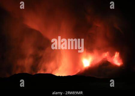 Ätna während einer suggestiven Eruption in der Nacht aus dem Vulkankrater mit imaginären Gesichtern und Formen, die durch Rauchemissionen erzeugt werden. August 2023 Stockfoto