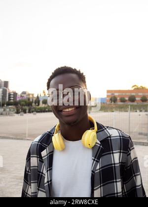 Porträt eines jungen, lächelnden afroamerikanischen Studenten, der auf dem Campus auf die Kamera schaut Stockfoto