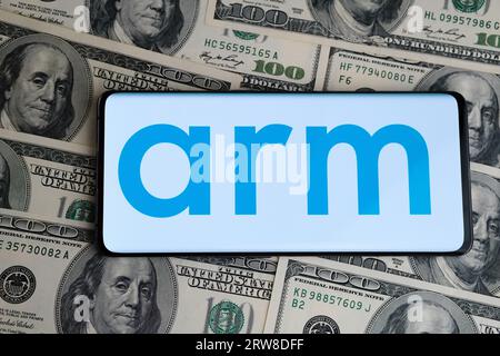 ARM-Logo auf Smartphone, das auf Hundert-Dollar-Scheine platziert wird. Konzept für den Börsengang von ARM-Unternehmen und Gewinne. London, Vereinigtes Königreich, 17. September 20 Stockfoto