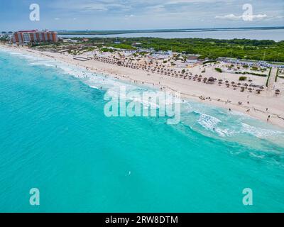 Entdecken Sie die Pracht der Küste von Cancún am Tag. Das türkisfarbene Wasser des Karibischen Meeres steht in wunderschönem Kontrast zu den weißen Wellen und dem Sand, wo Sie sind Stockfoto