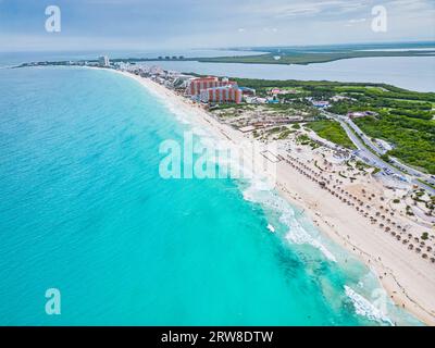 Entdecken Sie die Pracht der Küste von Cancún am Tag. Das türkisfarbene Wasser des Karibischen Meeres steht in wunderschönem Kontrast zu den weißen Wellen und dem Sand, wo Sie sind Stockfoto