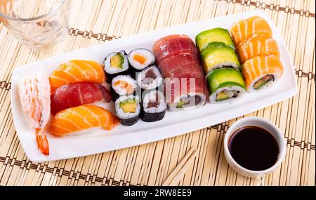 Sushi-Brötchen und Nigiri mit Lachs, Thunfisch, Avocado und Garnelen Stockfoto