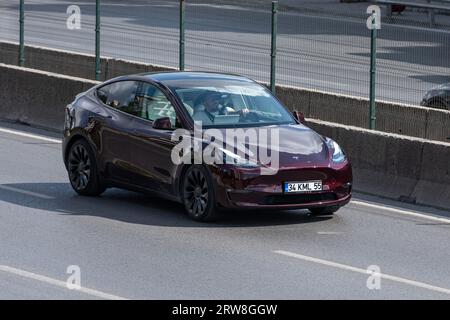 ISTANBUL, TÜRKEI - 17. SEPTEMBER 2023: Ein burgunderroter Tesla Model Y auf der Autobahn, Istanbul. Stockfoto