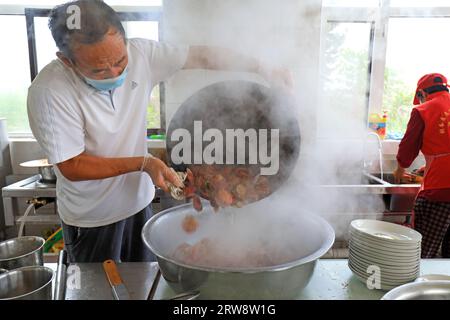 LUANNAN COUNTY, China - 16. September 2021: Köche kochen Jakobsmuscheln in der Küche, Nordchina Stockfoto