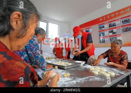 LUANNAN COUNTY, China - 16. September 2021: Freiwillige und alte Menschen machen traditionelle chinesische Mondkuchen in einem Dorf Stockfoto