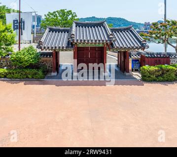 Wunderschöner Blick auf das traditionelle koreanische Ziegeldach und das rote Holztor Stockfoto