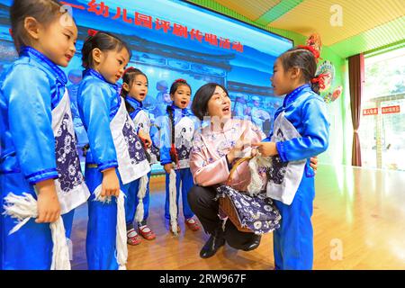 LUANNAN COUNTY, China - 18. Oktober 2021: A Pingju Performing Artist Guides Children to Learning Pingju, North China Stockfoto