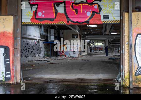 Vandalistisches, verlassenes Industriebau hinter halb offener Laderampe in Paimio, Finnland Stockfoto