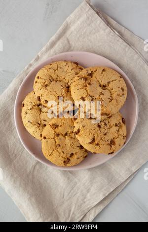 Hausgemachte Kekse mit Milchschokoladenbrocken auf einem Teller, Blick von oben. Flach liegend, über Kopf, von oben. Stockfoto