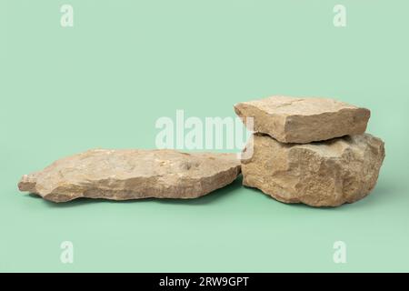 Steinpodium für die kosmetische Produktpräsentation. Abstrakter minimaler Hintergrund. Zwei Felsformen. Hellgrüner Studiohintergrund. Szene, die gezeigt werden soll. Showcase Stockfoto