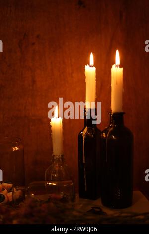 halloween Stillleben mit brennenden Kerzen und Augenbrauen in einem Glas Stockfoto
