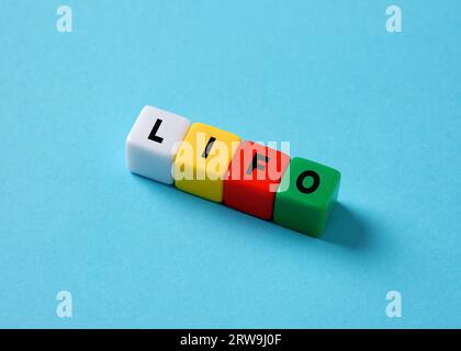 Last in First Out LIFO Concept. Geschäftsinventar oder Speichersystem. Die Abkürzung LIFO auf bunten Würfeln auf blauem Hintergrund. Stockfoto