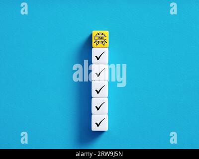 ISO-Zertifikat erhalten. Der Weg zur Zertifizierung von Qualitätsstandards. Erfüllung der iso-Normen. Bunte Würfel mit Häkchen und iso-Symbolen auf bl Stockfoto