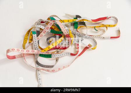 Studio, Hampshire UK. 2023. Buntes Band wird auf weißem Hintergrund verschlungen. Studio-Aufnahme. Stockfoto