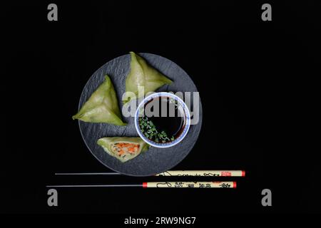 Gyoza, japanische Knödel mit Shiitake-Füllung auf Teller mit Stäbchen und Schüssel mit Sojasauce Stockfoto
