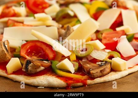 Tomaten, Käse, Oliven, Pilze, Zwiebeln werden auf einen ausgerollten Pizzateig gelegt Stockfoto