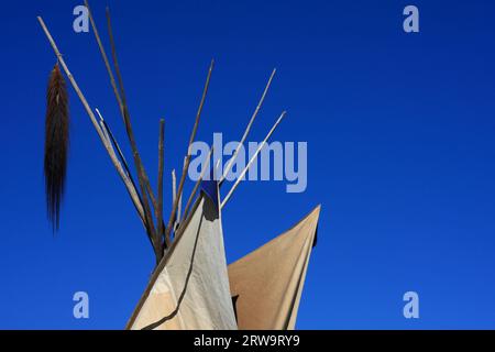 Weiß-braunes Indianerzelt mit Pferdeschwanz, blauer Himmel im Hintergrund Stockfoto