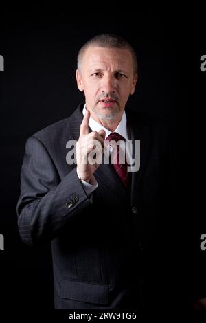 Unzufriedener reifer Mann, der seinen Zeigefinger schüttelt Stockfoto