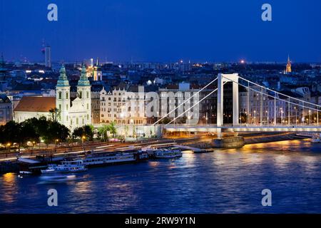 Stadtbild von Budapest in Ungarn bei Nacht mit innerstädtischer Pfarrkirche, Appartementgebäuden und Elisabethbrücke an der Donau Stockfoto