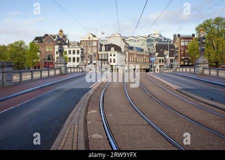 Straße und Straßenbahn auf der Hogesluis-Brücke (Hoge Sluis Brug), Verkehrsinfrastruktur in der Stadt Amsterdam in den Niederlanden, am frühen Morgen Stockfoto