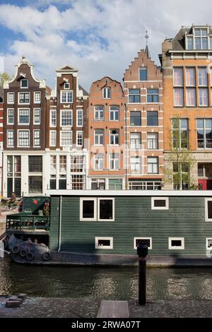 Kanalhäuser im niederländischen Stil und Wohnkahn an einem Kanal in Amsterdam, Holland, Niederlande Stockfoto