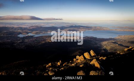 Blick vom Mount Wellington auf die Stadt Hobart, Tasmanien, Australien mit Felsen im Nachmittagslicht Stockfoto