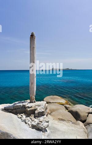 Ein kleiner Hafen an der Cava Usai, mit dem Leuchtturm Isola di Cavoli im Hintergrund, Capo Cabonara, Villasimius, Sarrabus, Provinz Cagliari Stockfoto