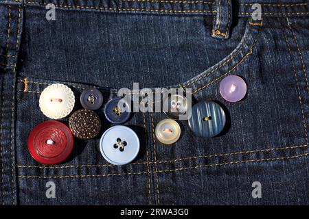 Knöpfe in verschiedenen Farben und Größen, auf der Tasche einer Jeans angenäht Stockfoto