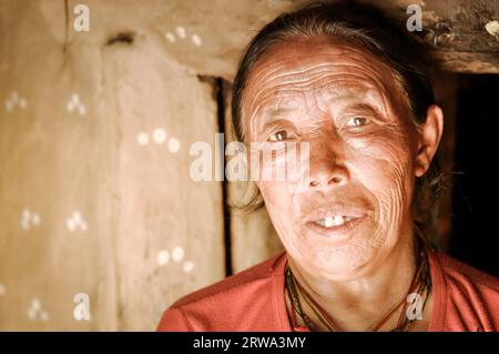 Dolpo, Nepal, um Mai 2012: Alte gebürtige Frau mit Falten und hellbraunen Augen in ihrem Haus in Dolpo, Nepal. Dokumentarisches Editorial Stockfoto