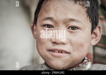 Kanchenjunga Trek, Nepal, ca. Mai 2012: Foto eines Jungen mit schönen braunen Augen, der auf eine Fotokamera in Kanchenjunga Trek, Nepal schaut. Stockfoto