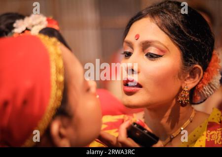 Guwahati, Assam, um April 2012: Beautiful Girl with red dot on her Head helps another Girl with Make-up before their performence at Bihu Stockfoto