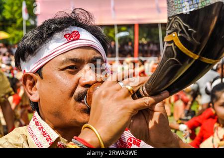 Guwahati, Assam, um April 2012: Der gebürtige Mann bläst Horn während des traditionellen Bihu-Festivals in Guwahati, Assam. Dokumentarisches Editorial Stockfoto