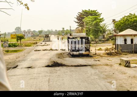 Nepal, ca. Mai 2012: Foto von langer Straße mit Bus und Haus verbrannt in Nepal Generalstreik. Dokumentarisches Editorial Stockfoto