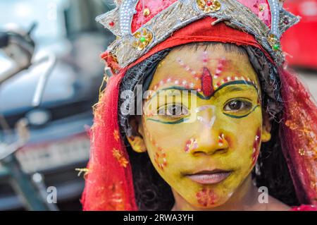 Silchar, Assam, um April 2012: Ein junges Mädchen mit gelber Farbe und schönen Ornamenten im Gesicht trägt einen roten Schleier in Silchar, Assam. Dokumentarfilm Stockfoto