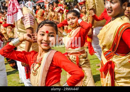 Guwahati, Assam, um April 2012: Junges einheimisches Mädchen in rotem und gelbem Sari mit rotem Punkt auf der Stirn beim Tanz beim traditionellen Bihu-Festival in Stockfoto