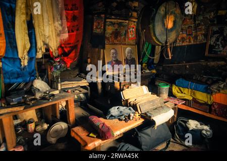 Dolpo, Nepal, um Juni 2012: Foto des Zimmers mit vielen Dingen wie Porträts berühmter Mönche, Taschen und kleinen Brettern mit Schrift und anderen Dingen Stockfoto