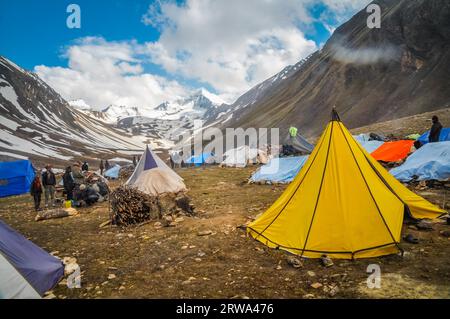 Dolpo, Nepal, um Juni 2012: Foto von bunten Zelten im Tal, umgeben von wunderschönen schneebedeckten Bergen in Dolpo, Nepal. Dokumentarfilm Stockfoto